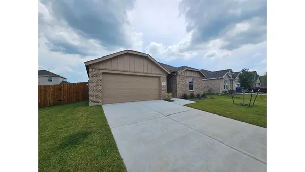 a view of a house with a yard and a large tree