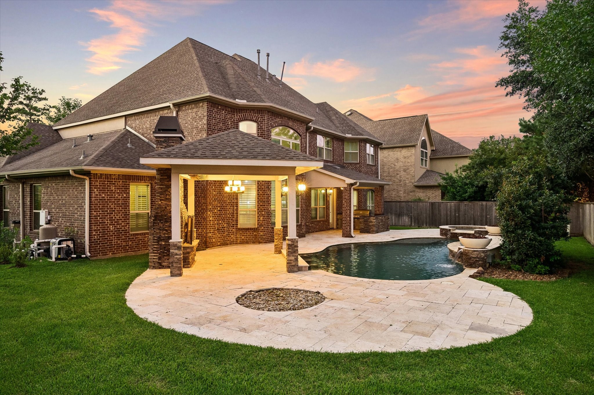 35 North Fremont Ridge Loop Spring, TX 77389 - Photo 32 of 37 This beautifully designed outdoor living space offers a resort-style pool and spa, outdoor kitchen, expansive travertine decking, and a separate covered patio with fireplace, an inviting setting for entertaining or enjoying quiet evenings under the Texas sky.