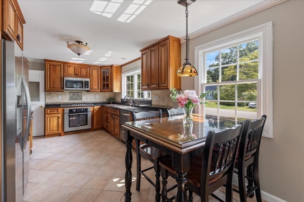 12 Bay Path Kingston, MA 02364 - Photo 4 of 24 a kitchen with stainless steel appliances granite countertop a stove a refrigerator a kitchen island a table and chairs