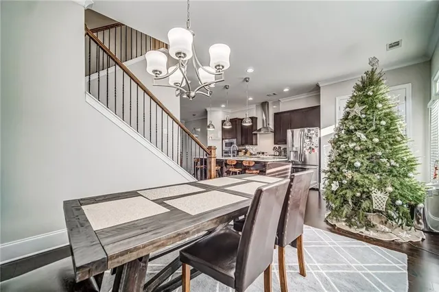 a view of a dining room with furniture a chandelier and wooden floor