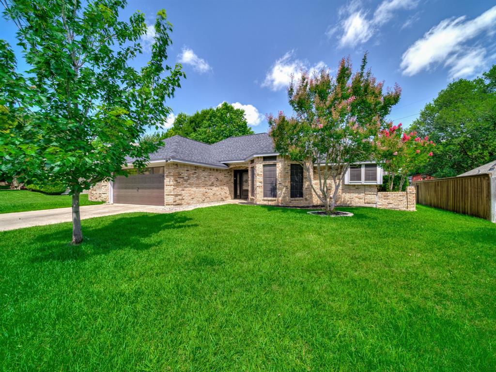 121 Northeast Brushy Mound Road Burleson, TX 76028 - Photo 3 of 35 a front view of a house with a garden and yard