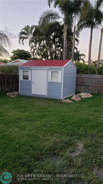 1721 Southwest 10th Street Boca Raton, FL 33486 - Photo 8 of 8 a view of a house with a yard and many windows
