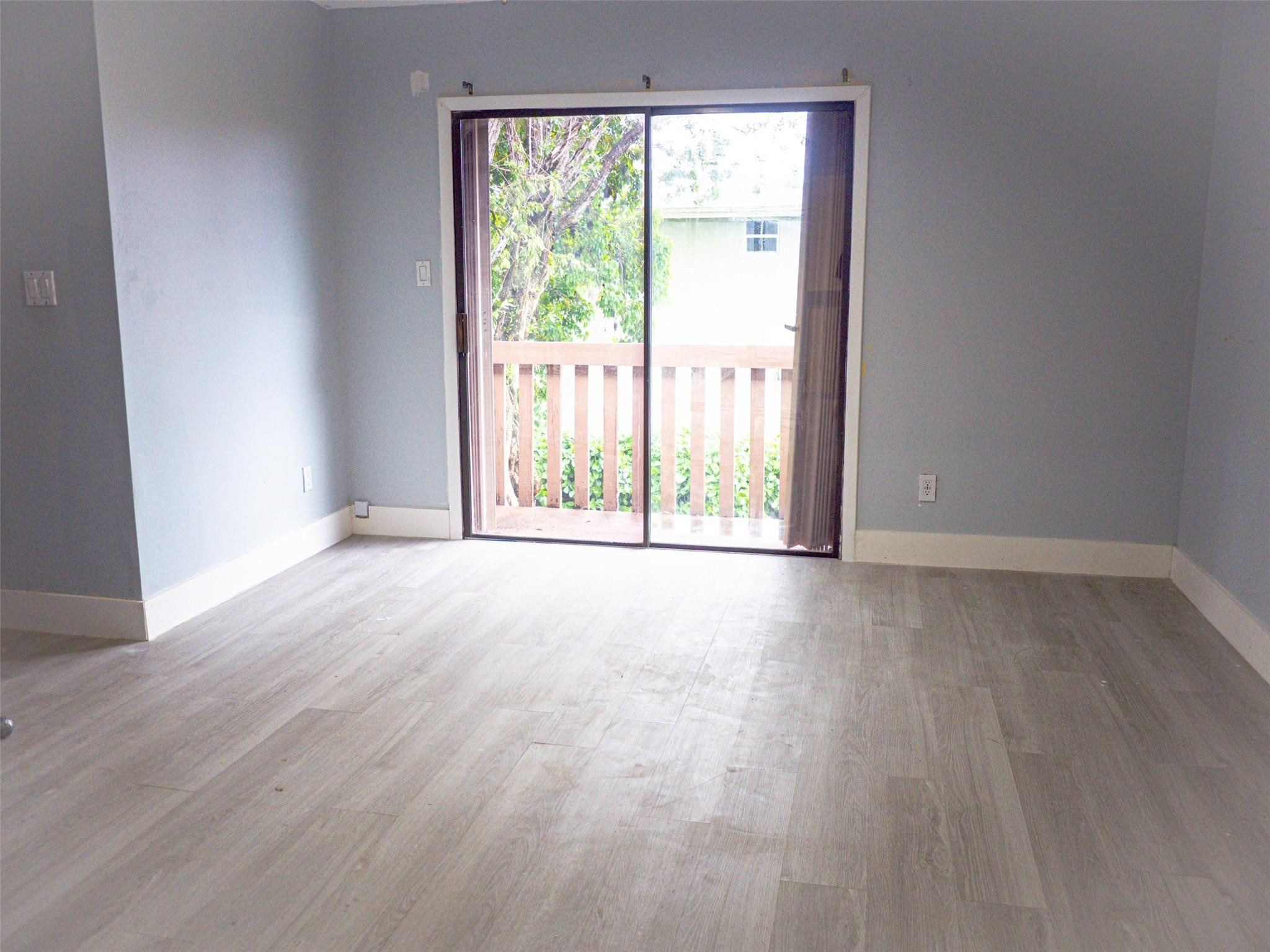 Undisclosed Address Tamarac, FL 33319 - Photo 14 of 21 an empty room with wooden floor and windows