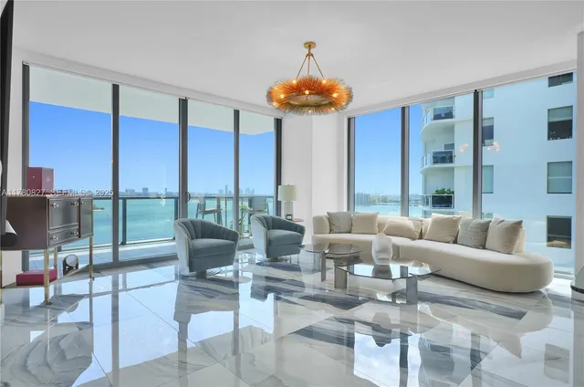 a living room with patio furniture and a large window