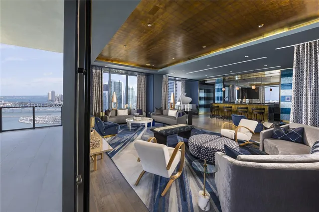 a large kitchen with kitchen island a large counter top stainless steel appliances and cabinets