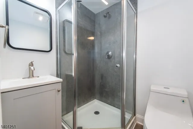 a bathroom with a sink a mirror a toilet and shower