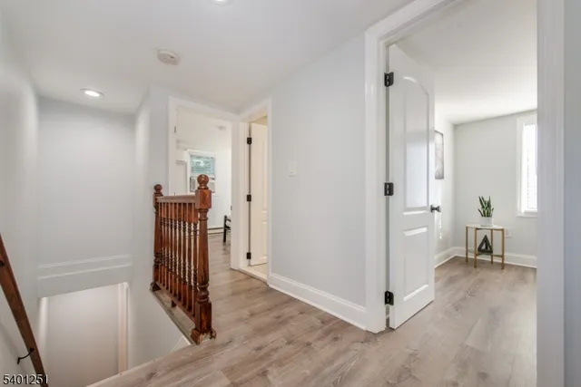 a view of a hallway with wooden floor and a livingroom