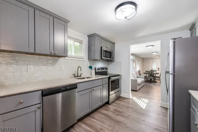 a kitchen with a sink dishwasher a stove and a refrigerator with wooden floor