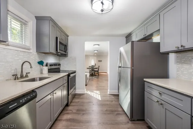 a kitchen with stainless steel appliances a refrigerator sink and cabinets