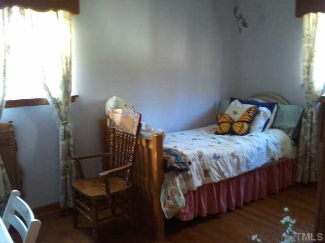 1421 Sykes Road Spring Hope, NC 27882 - Photo 6 of 11 a bedroom with a bed a window and chair