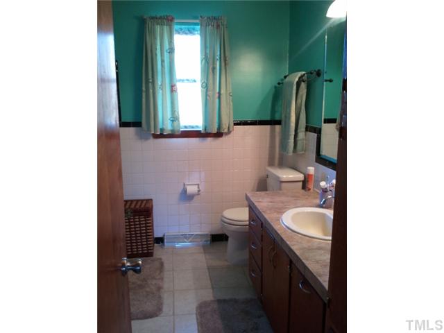 1421 Sykes Road Spring Hope, NC 27882 - Photo 7 of 11 a bathroom with a granite countertop sink and a mirror