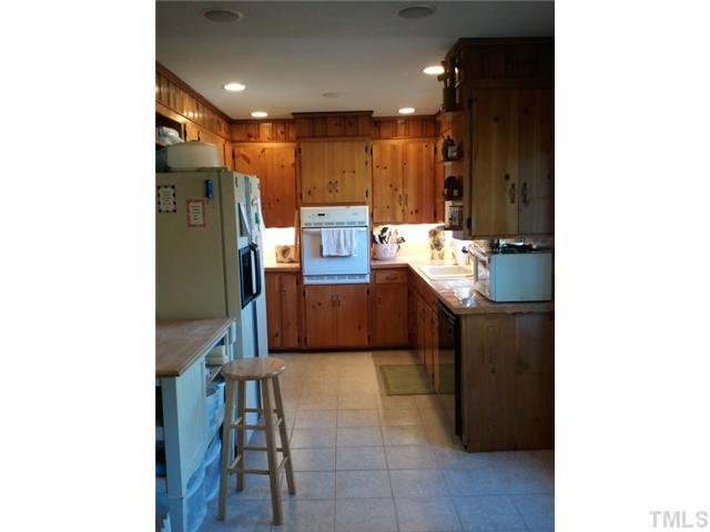 1421 Sykes Road Spring Hope, NC 27882 - Photo 9 of 11 a kitchen with refrigerator and chairs