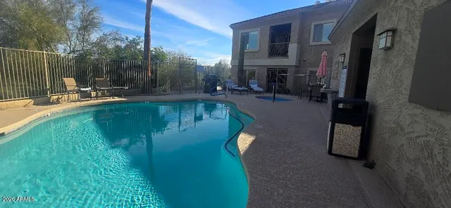 a view of a patio with a table chairs and a floor to ceiling window