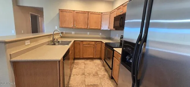 a kitchen with stainless steel appliances granite countertop a refrigerator a stove and a sink