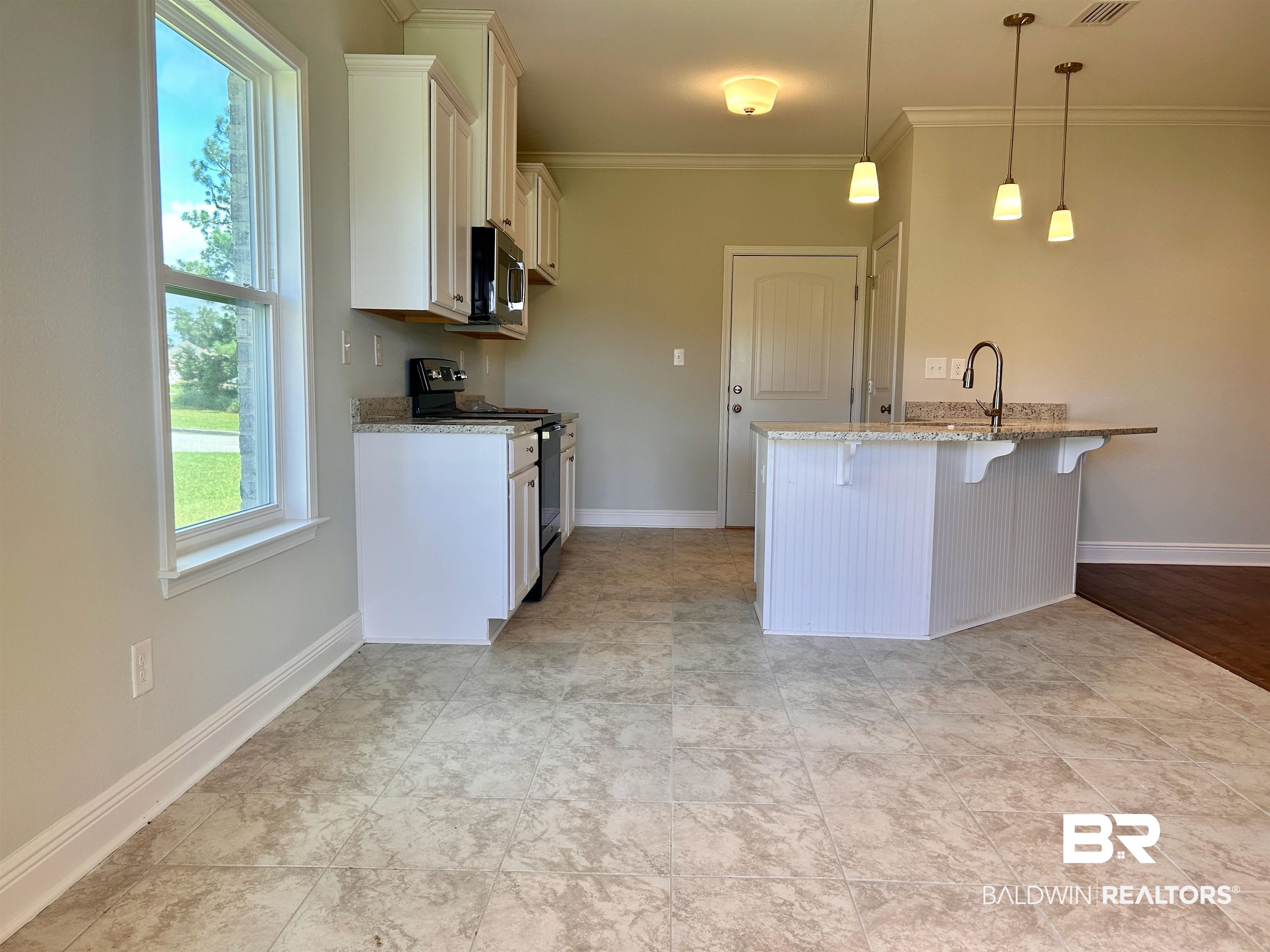 1267 Pembroke Way Foley, AL 36535 - Photo 11 of 17 Kitchen featuring crown molding, decorative light fixtures, a kitchen breakfast bar, electric range oven, and light stone countertops