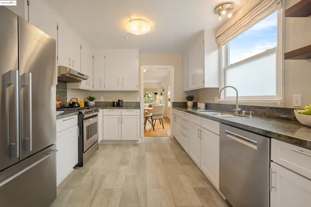 a kitchen with granite countertop white cabinets and white appliances