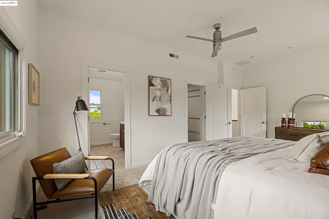 a bedroom with a bed chairs and window