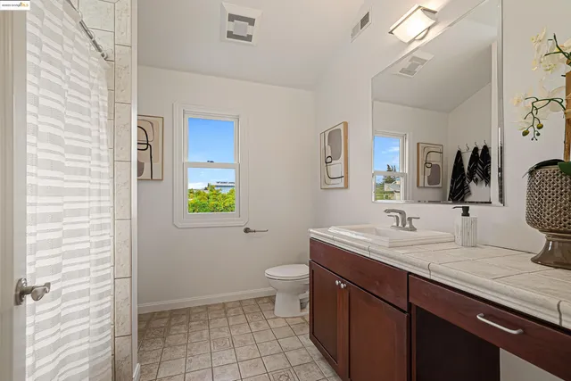 a bathroom with a double vanity sink toilet and mirror