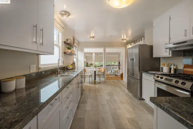 a kitchen with stainless steel appliances granite countertop a sink stove and refrigerator