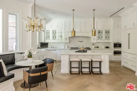 a white kitchen with stainless steel appliances granite countertop a stove a sink and white cabinets