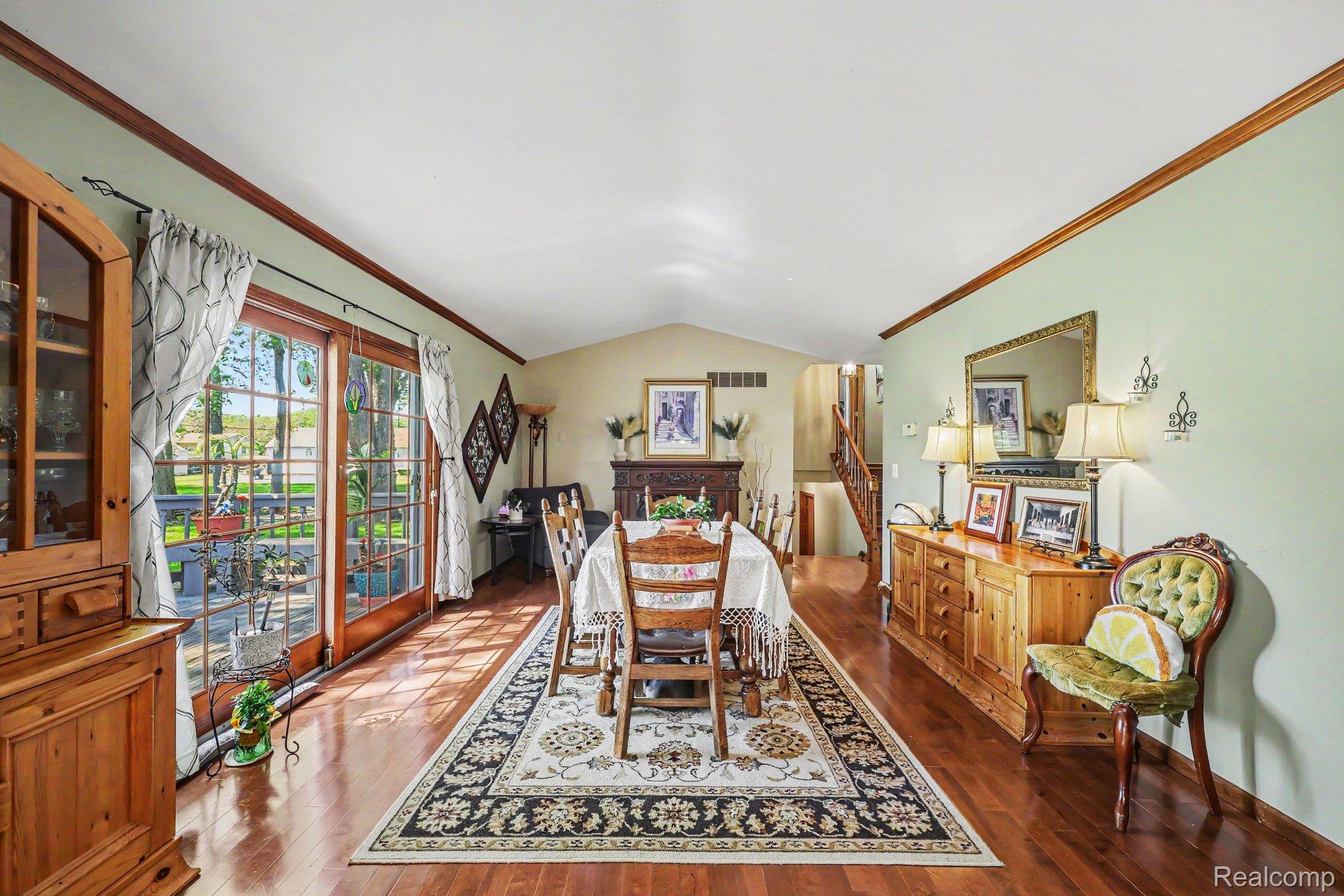 7020 Meldrum Road Fair Haven, MI 48023 - Photo 11 of 43 Spacious room featuring wood-finish flooring, wood-framed glass patio doors, and a vaulted ceiling