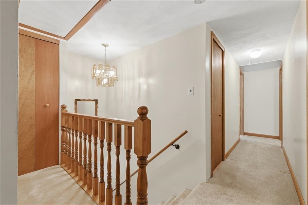 107 Oak Street Pembroke, MA 02359 - Photo 19 of 38 a view of a hallway with a chandelier