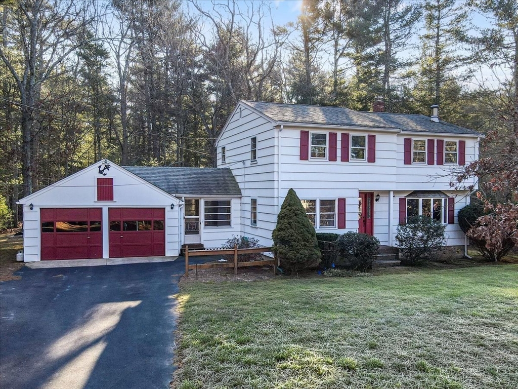 107 Oak Street Pembroke, MA 02359 - Photo 2 of 38 a front view of a house with a garden and trees