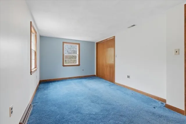 an empty room with windows and closet