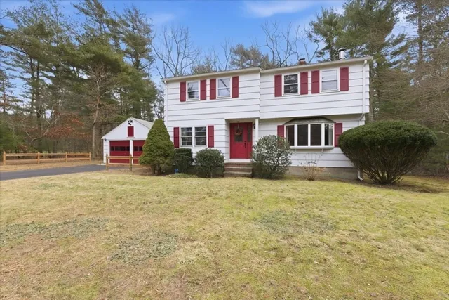 a front view of a house with large trees