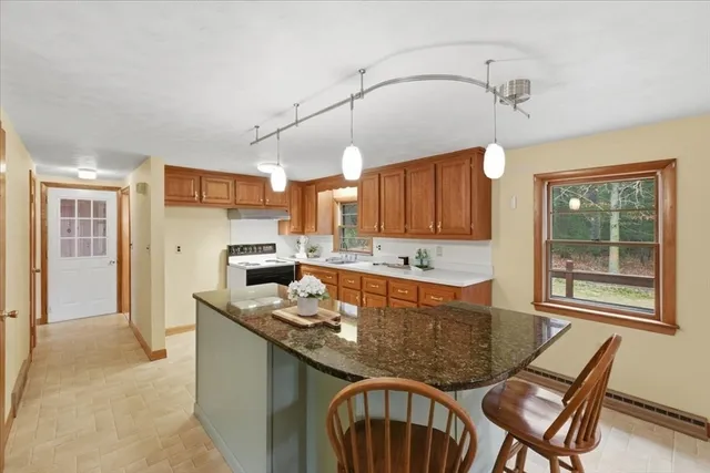 a kitchen with stainless steel appliances granite countertop a sink a stove and a refrigerator