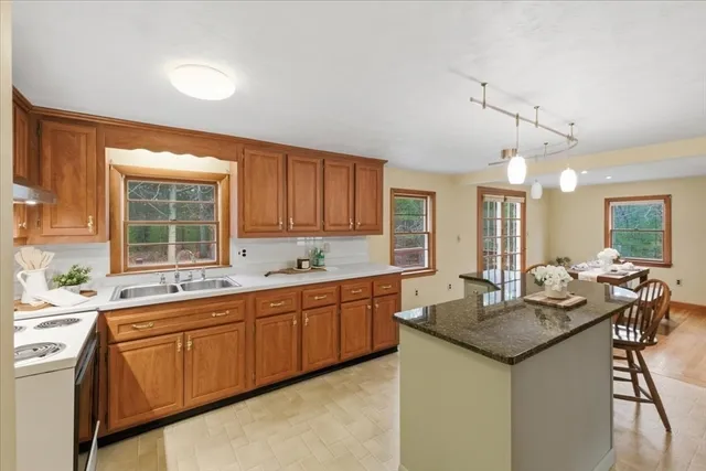 a kitchen with granite countertop sink stove and cabinets