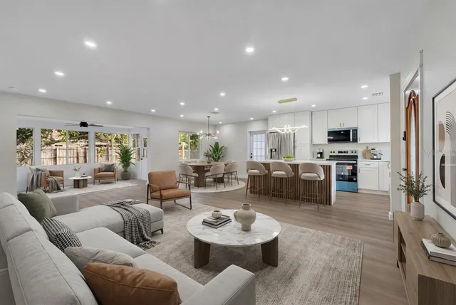 a living room with furniture kitchen and a wooden floor