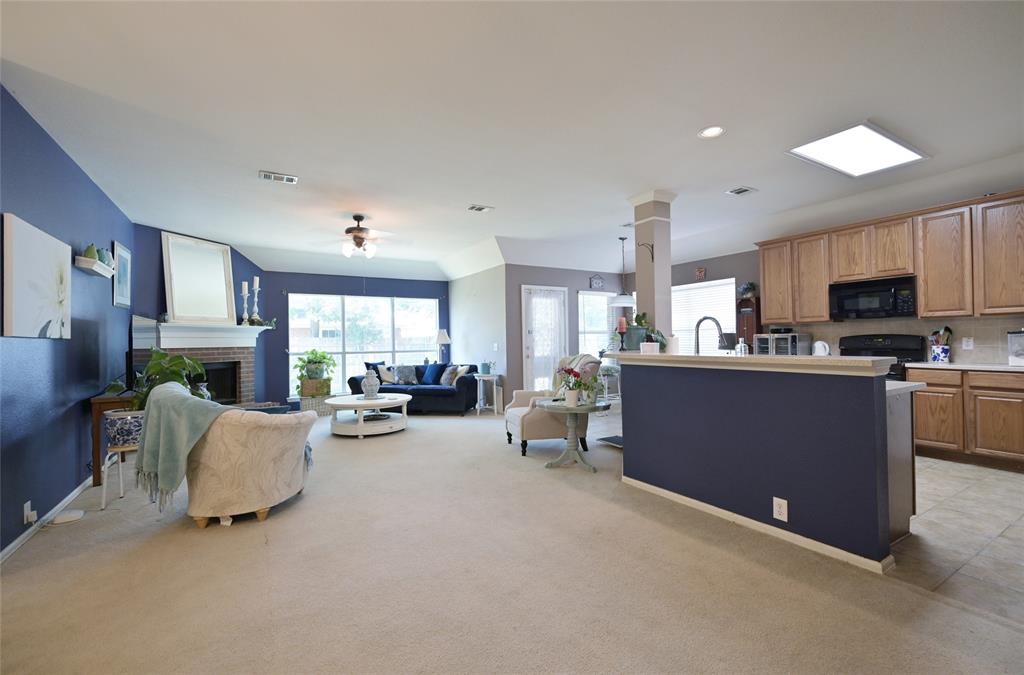 4509 Butterfly Way Fort Worth, TX 76244 - Photo 12 of 40 a living room with furniture a fireplace and a open kitchen view