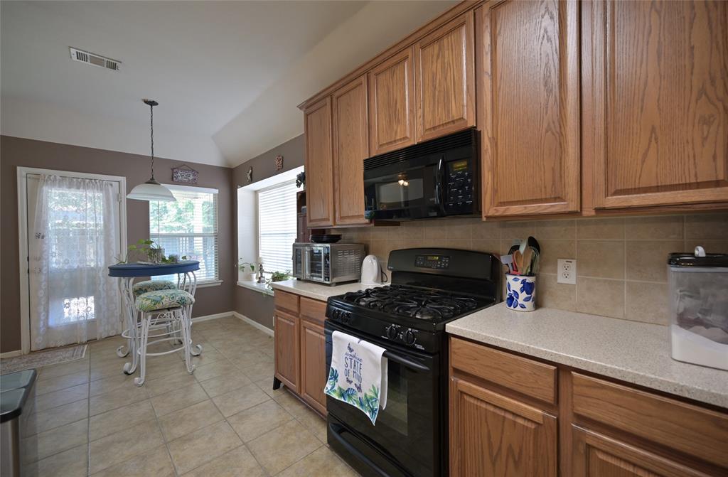 4509 Butterfly Way Fort Worth, TX 76244 - Photo 7 of 40 a kitchen with granite countertop a stove a sink dishwasher and cabinets with wooden floor