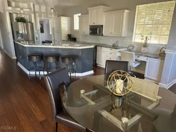 a view of dining room and kitchen with furniture wooden floor and a chandelier