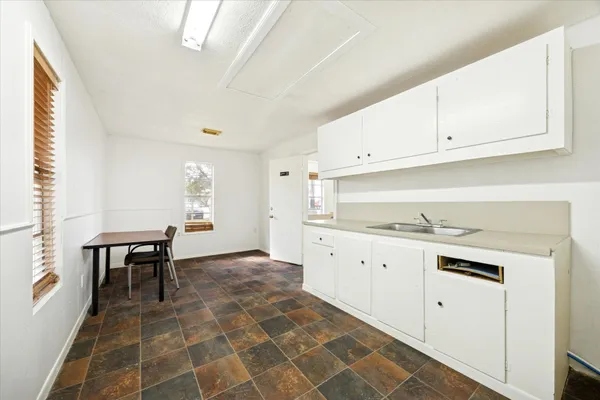 a kitchen with granite countertop white cabinets and white appliances