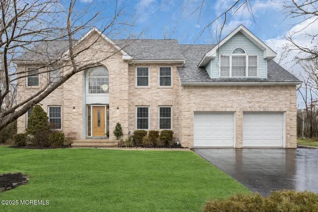 a front view of a house with a garden and yard