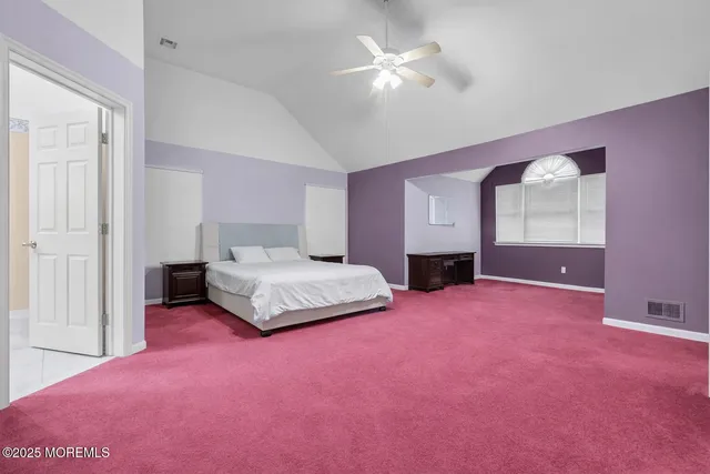 a spacious bedroom with a bed and a chandelier