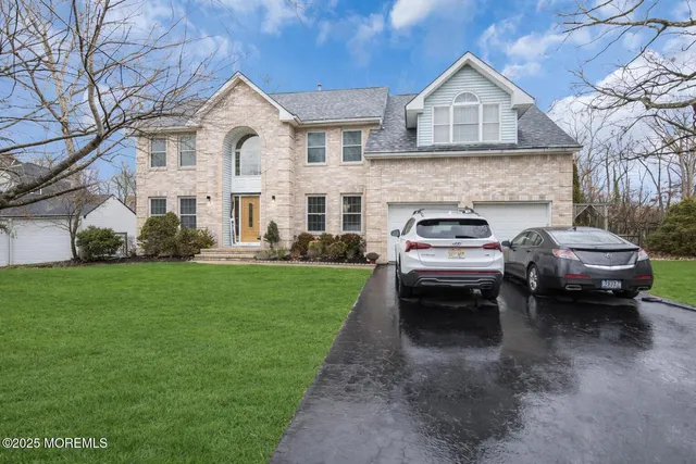 a view of a white car parked in front of a house with a yard