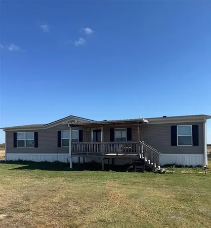 a backyard of a house with yard table and chairs