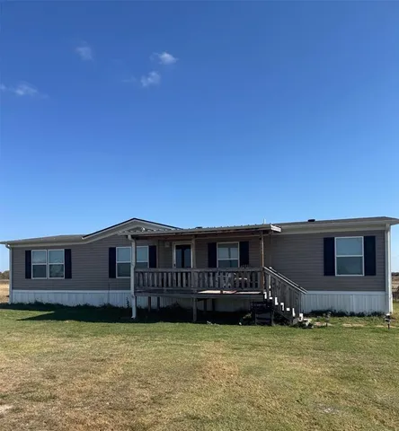 a backyard of a house with yard table and chairs