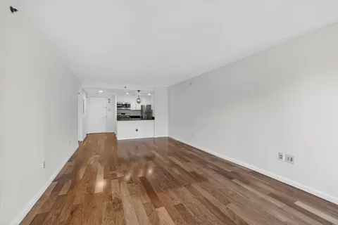 a view of empty room with kitchen