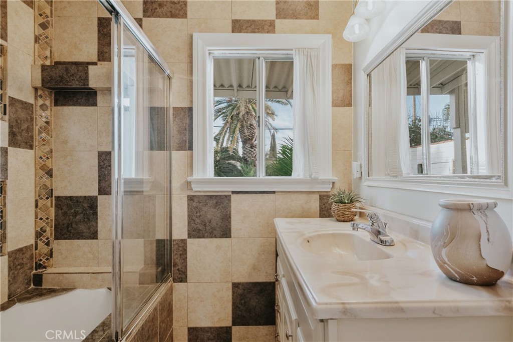 1502 East 57th Street Long Beach, CA 90805 - Photo 21 of 31 a bathroom with a sink and a large mirror
