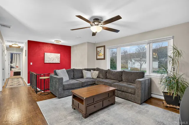a living room with furniture and a large window with wooden floor
