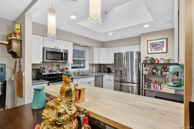 a kitchen with stainless steel appliances wooden floor and refrigerator