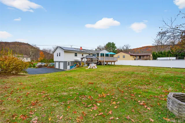 a view of a house with a big yard and large trees