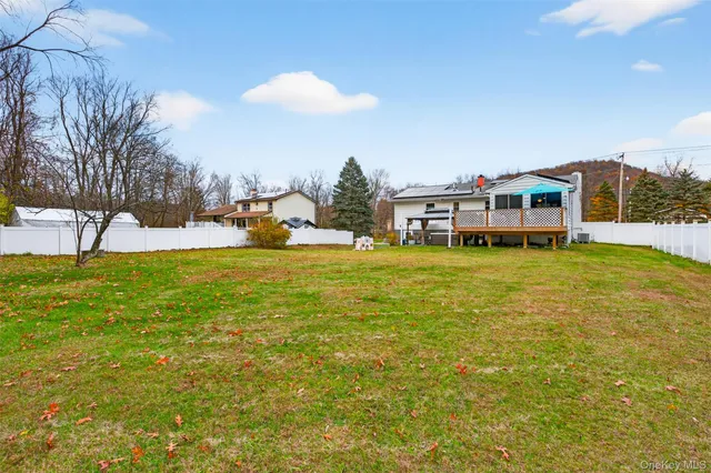 a view of a house with a wooden deck and a chair