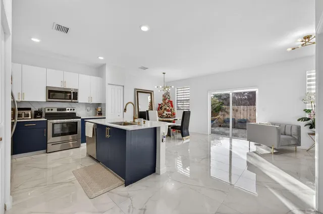 a kitchen with stainless steel appliances granite countertop a sink stove and refrigerator
