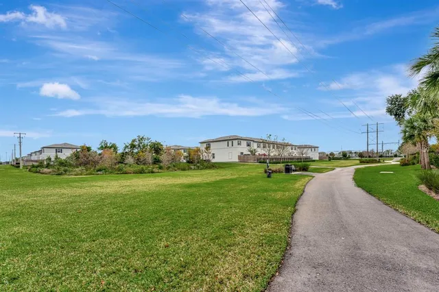 an aerial view of residential houses with outdoor space and trees