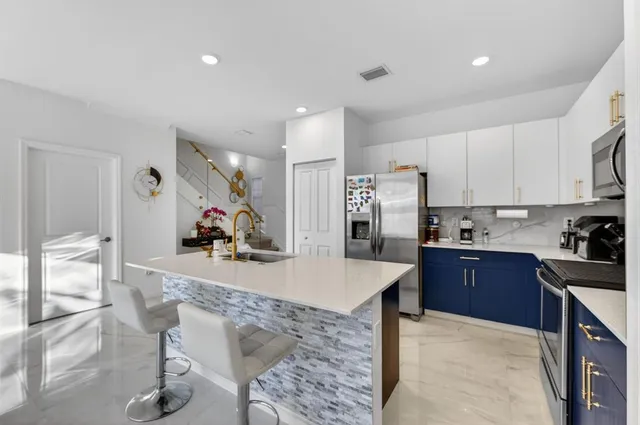 a kitchen with stainless steel appliances granite countertop a refrigerator and a stove top oven